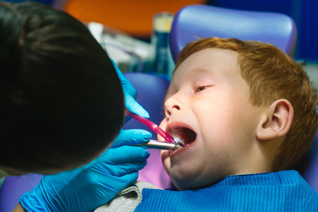 pediatric dental emergency a woman examines a child's mouth during a pediatric dental emergency