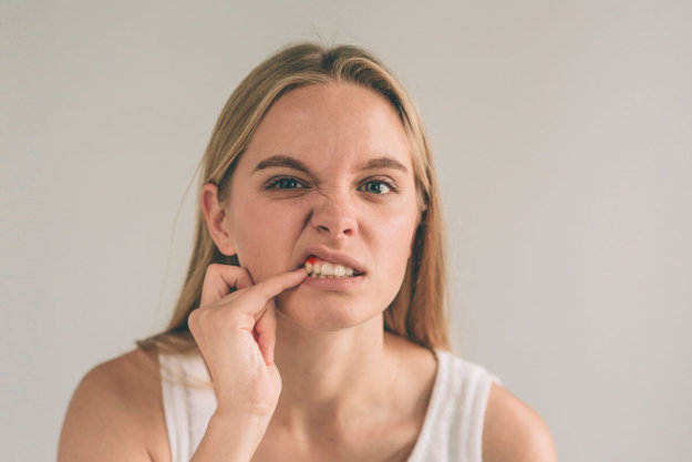woman examining her teeth for gum disease