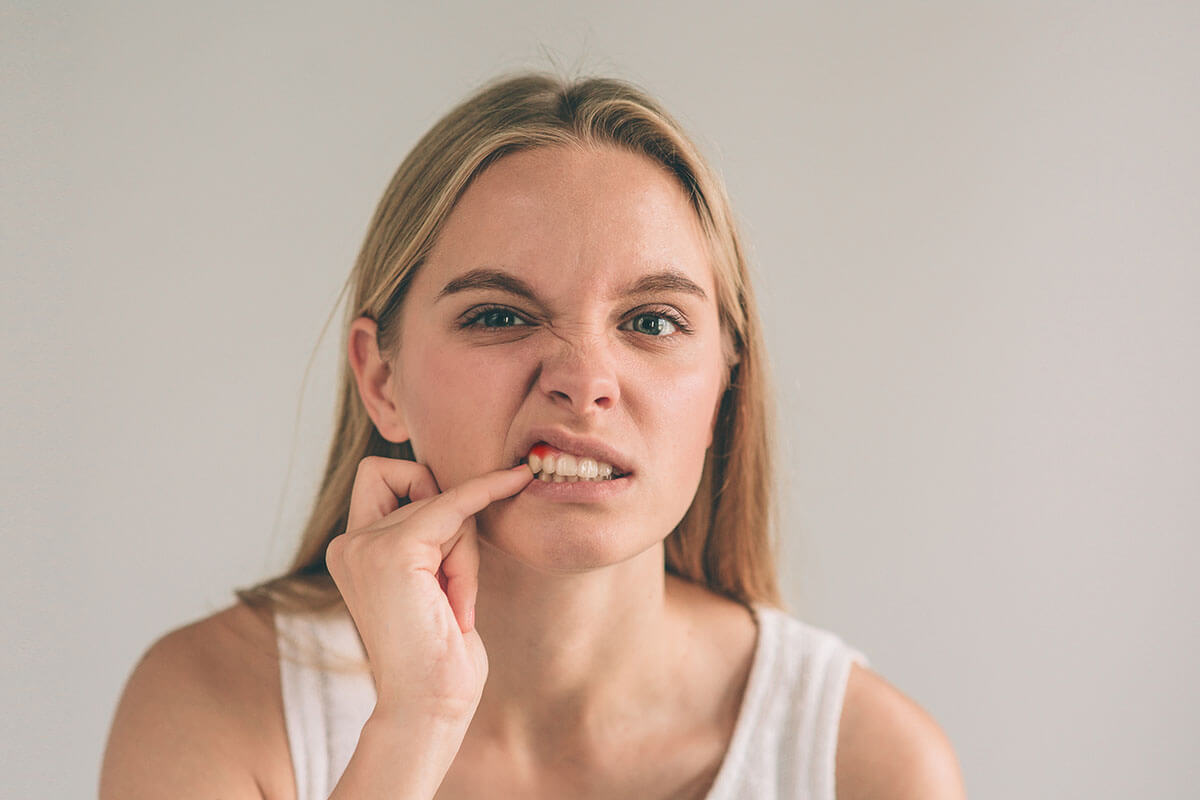 woman examining her teeth for gum disease