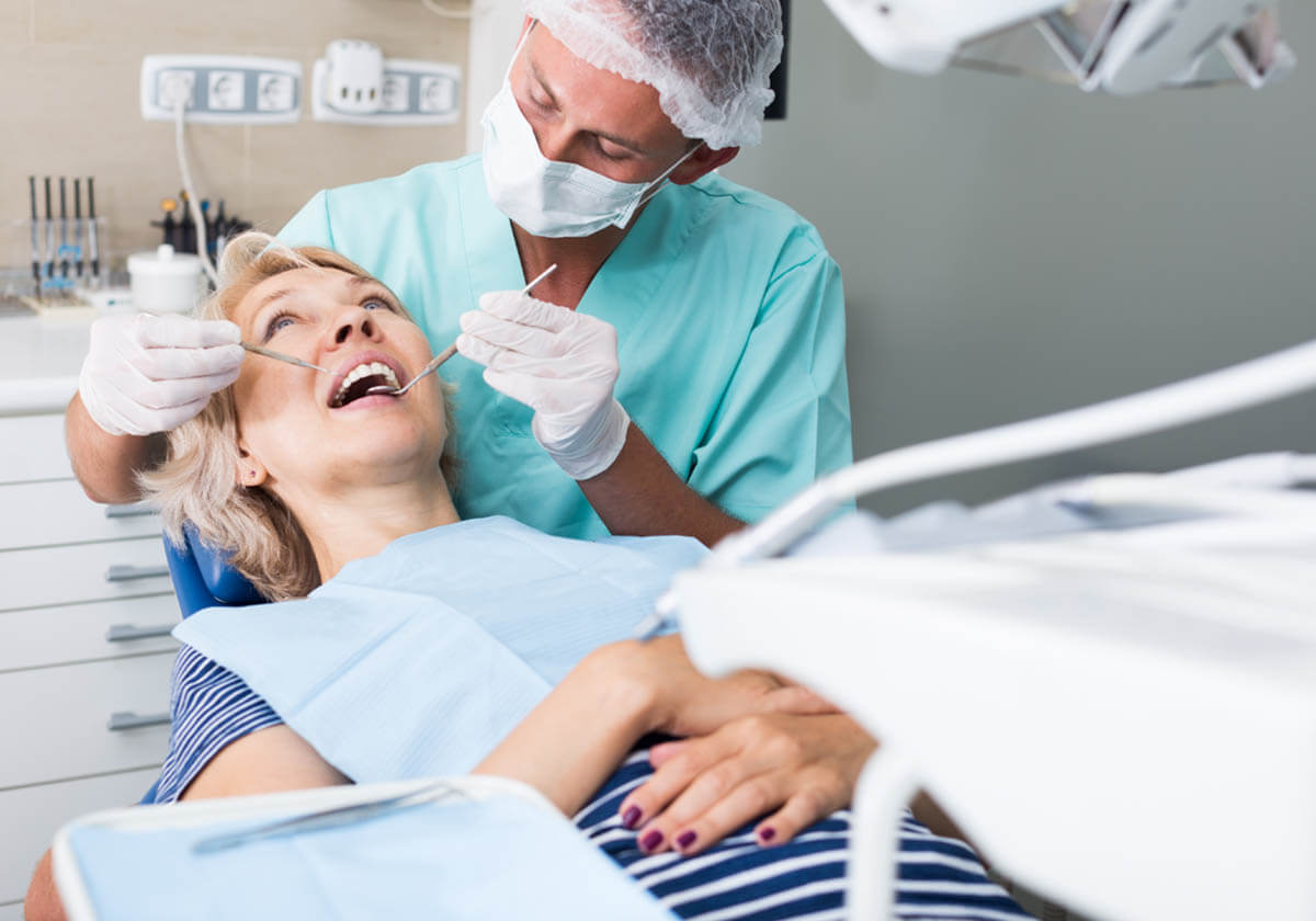 woman getting teeth cleanings by dentist
