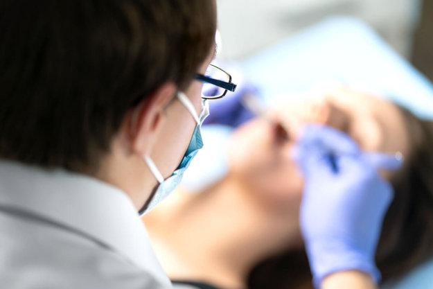 Wisdom Teeth Removal dentist performs a wisdom teeth removal on a patient