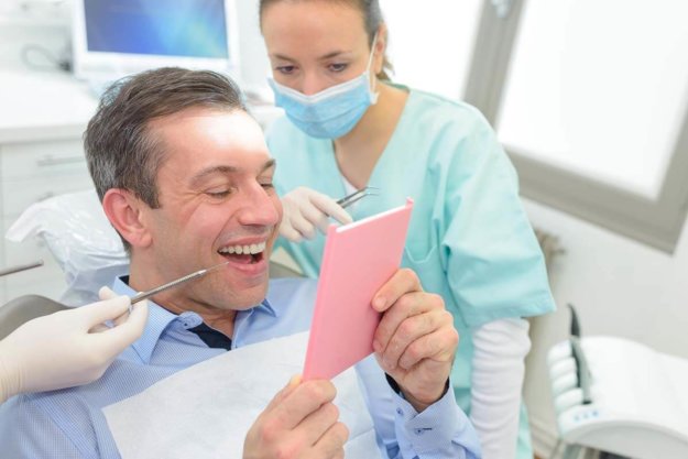 How Long Do Dental Crowns Last_ a patient smiles at his new dental crowns and asks his dentist how long do dental crowns last
