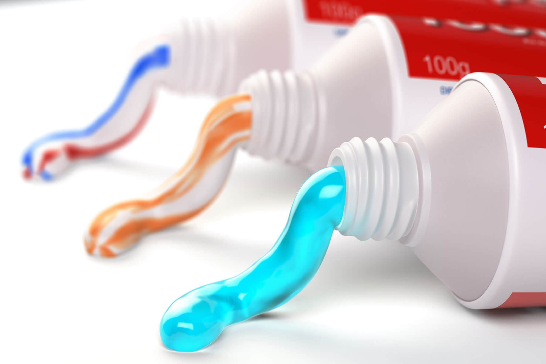 three tubes of toothpaste for veneers with toothpaste coming out of the top of the tubes