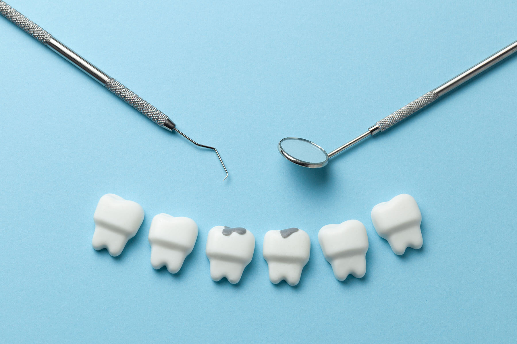 six model teeth and dental tools lay down after being used to practice the dental filling procedure