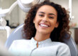 patient smiles big while sitting in exam chair and asks dentist how long after fluoride can i eat