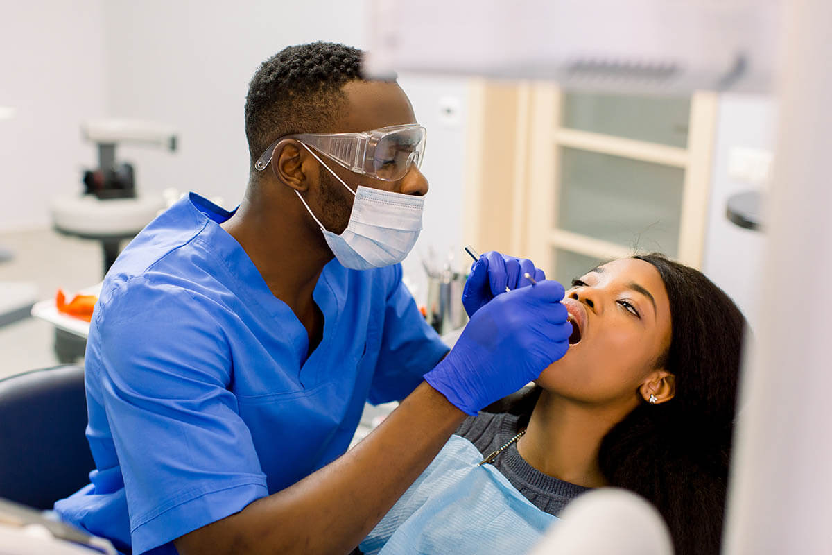 a dentist is working on a patient's mouth and answers the patient's question about is a dental deep cleaning ever really necessary?