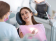 woman lays back in dental exam chair and asks dental professional how long does teeth whitening last
