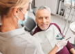 male dental patient sits in a chair while he gets molds done for natural looking dentures