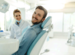 a dentist and a patient sit in an exam room and smile after the dentist answered the patients question about when to consider teeth whitening