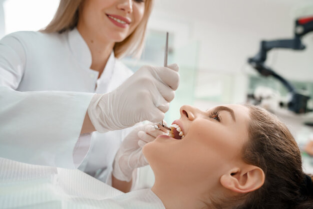 a dentist expert works on a patients mouth after patient asked how to find a good cosmetic dentist
