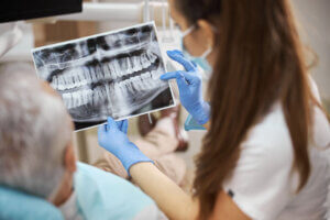 a dental professional at one of supreme dentistrys locations shows a patient their xray of their mouth