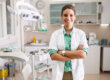 a dentist in family dentistry in houston tx smiles while standing in her office's dental exam room